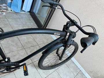 Bici nera stile Harley con sella in cuoio