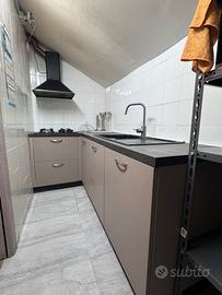 Cucina con piano cottura lavabo e cappa