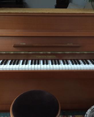 Pianoforte verticale con seduta.