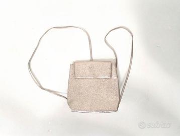 Zaino rosa con chiusura a bottone magnetico.