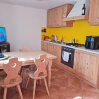 Cucina completa con tavolo, sedie e divano-letto