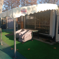 Casetta in legno campeggio con roulotte e veranda