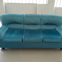 Divano tre posti in tessuto color smeraldo.