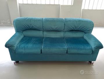 Divano tre posti in tessuto color smeraldo.