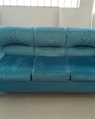 Divano tre posti in tessuto color smeraldo.