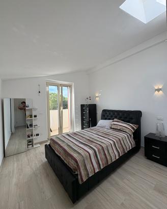 Camera con letto,comodino, cassettiera e scarpiera