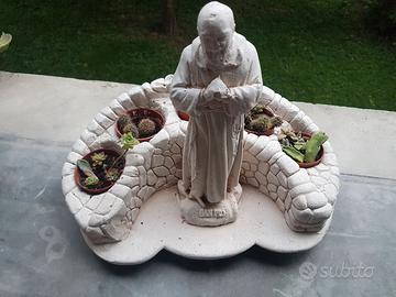 Statua Padre Pio con piante.
