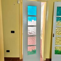 Porta scorrevole in legno con parti in vetro