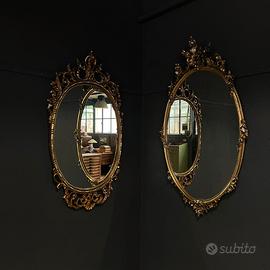 Specchio ovale con cornice dorata e intarsiata