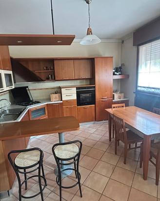 Cucina ad angolo completa con penisola e tavolo