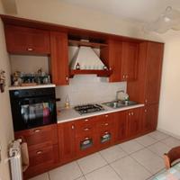 cucina completa in legno con tavolo e sedie 