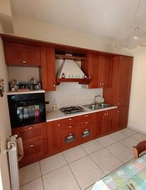 cucina completa in legno con tavolo e sedie 