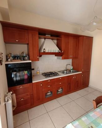 cucina completa in legno con tavolo e sedie 