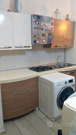 cucina ,divano letto, tavola e sedie e lampadario