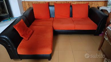 divano angolare pelle nera cuscini arancioni 