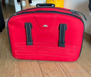 Valigia rossa con manico e rotelle