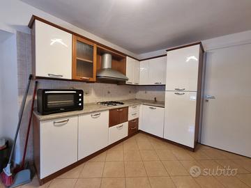 Cucina ad angolo bianca e legno.