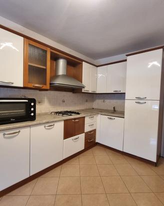 Cucina ad angolo bianca e legno.