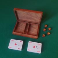 Scatola in legno con carte e dadi.
