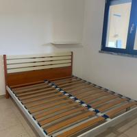 Letto matrimoniale con rete a doghe.