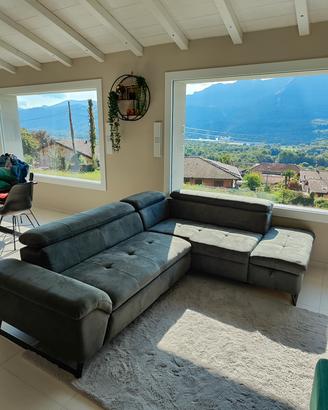 Divano con penisola, tappeto e pouf.
