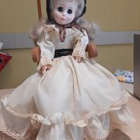 Bambola vintage su sedia a dondolo