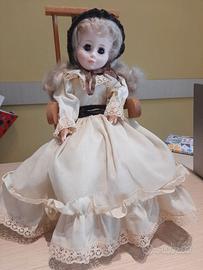 Bambola vintage su sedia a dondolo