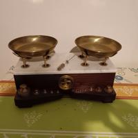 Bilancia antica a due piatti e pesi in ottone.