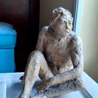 Statua di uomo seduto che guarda lontano