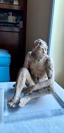 Statua di uomo seduto che guarda lontano