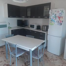 Cucina attrezzata e parete salone