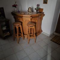 Bancone bar in legno con sgabelli abbinati