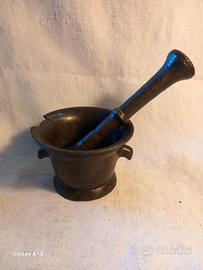 Mortaio in bronzo con crepe e pestello.