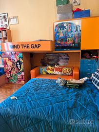 Camera a ponte decorata pop art con letto e armadi