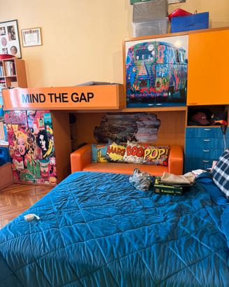 Camera a ponte decorata pop art con letto e armadi