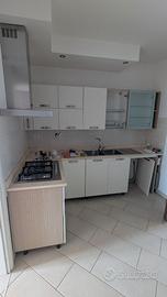 Cucina con lavello, piano cottura e cappa