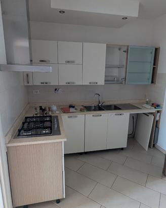 Cucina con lavello, piano cottura e cappa