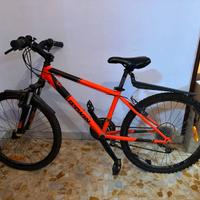 Bici B-twin di colore arancione e nero