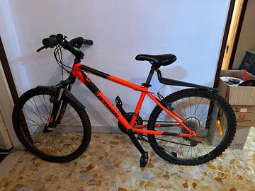 Bici B-twin di colore arancione e nero