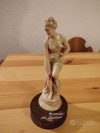 Statuetta in resina marmorizzata e base in legno
A