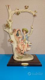 Statuetta scultura resina con base in legno.