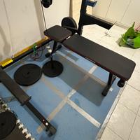 Rack con bilancieri, dischi di ghisa e carrucola.