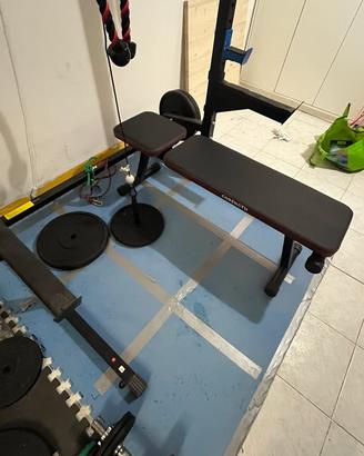 Rack con bilancieri, dischi di ghisa e carrucola.