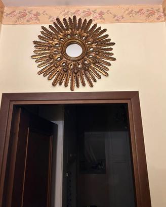 specchio con cornice dorata a raggiera