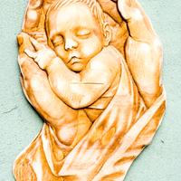 Bassorilievo in Legno. Bambino in mano, neonato