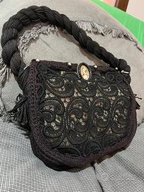Pochette in pizzo nero con spilla