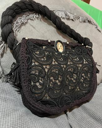 Pochette in pizzo nero con spilla