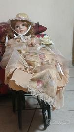 bambola di porcellana con carrozzella