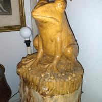 Grande scultura lignea di una rana.
