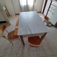 vecchio tavolo con taglieri e mattarello e 3 sedie